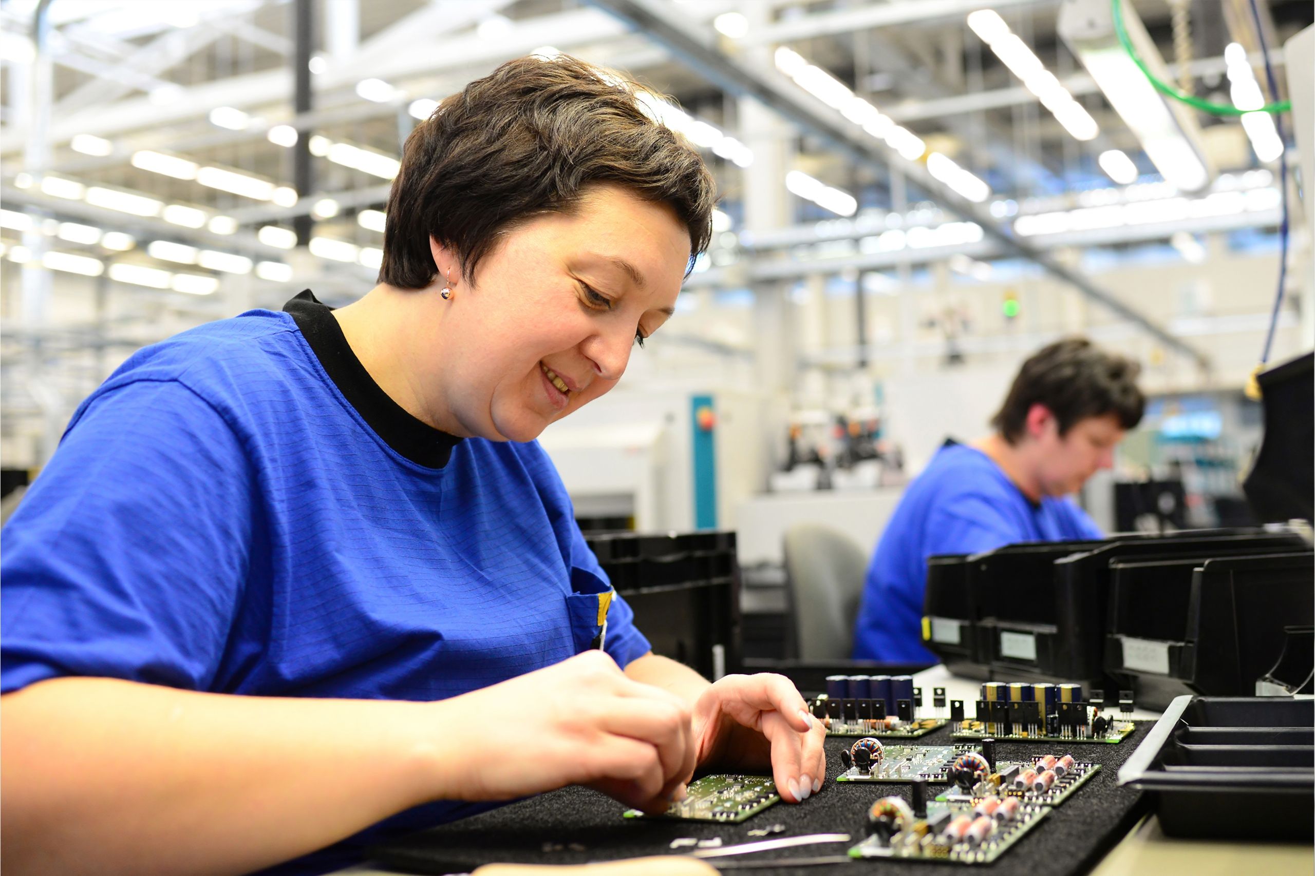 Woman working in manufacturing plant in entry-level manufacturing job