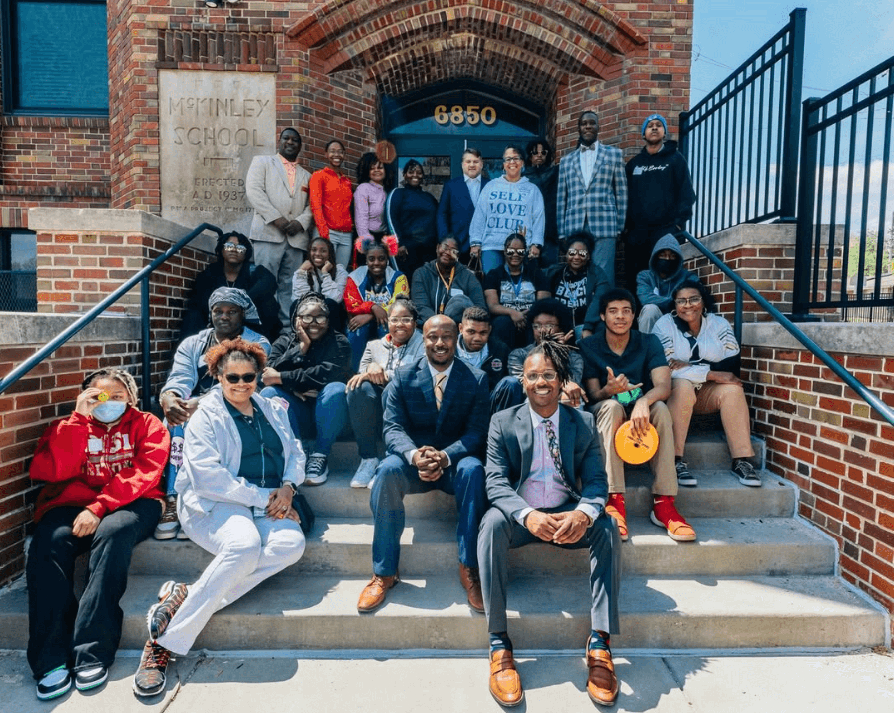 A group of workforce development students posing in front of building.